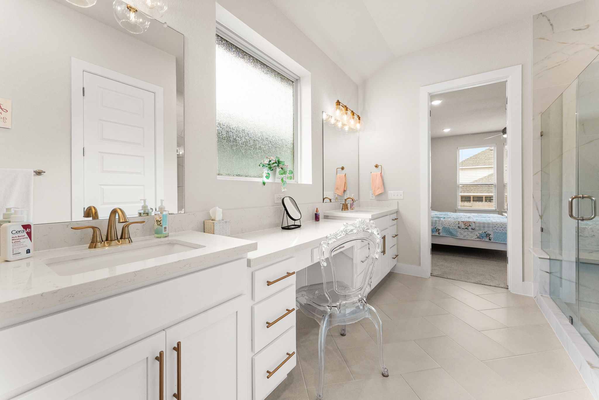 9508 Hamadryas Drive Austin, TX 78744 - Photo 19 of 40 The master bathroom has herringbone tile flooring, multi-height vanity with two sinks, a frameless shower with bench, water closet, and rainfall window.