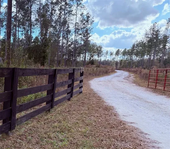 a view of a yard with wooden fence