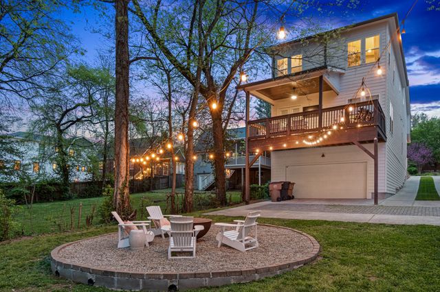 a kitchen with stainless steel appliances granite countertop a refrigerator a sink dishwasher a oven with white cabinets and wooden floor