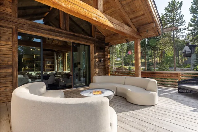 a view of a patio with couches and a table and chairs with wooden floor and fence