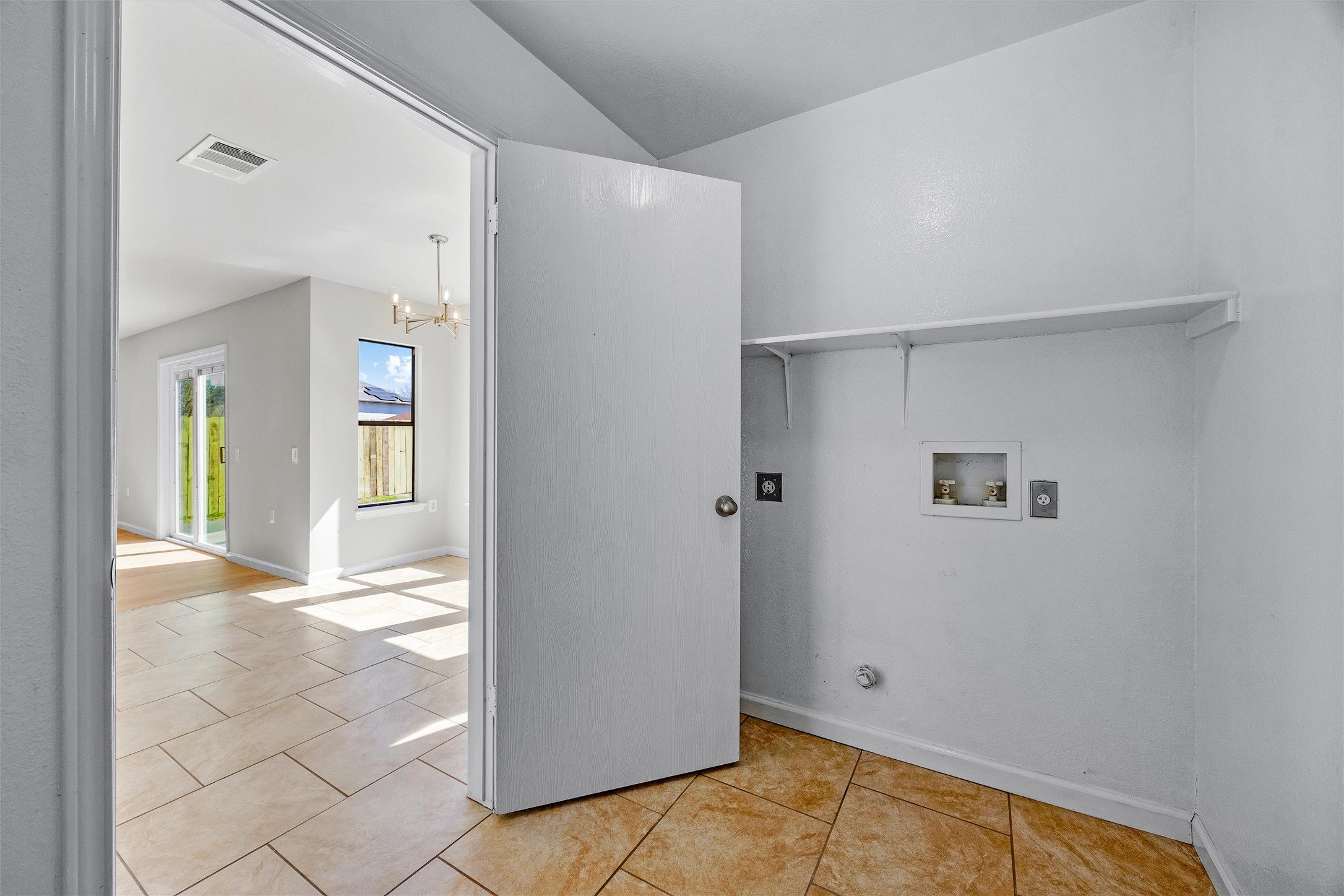 7541 Redrick Drive Austin, TX 78747 - Photo 24 of 40 Washroom featuring tile patterned floors, visible vents, a notable chandelier, washer hookup, and laundry area