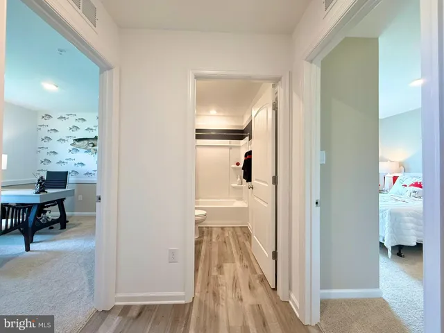 a view of a hallway to a livingroom and a dining room with furniture