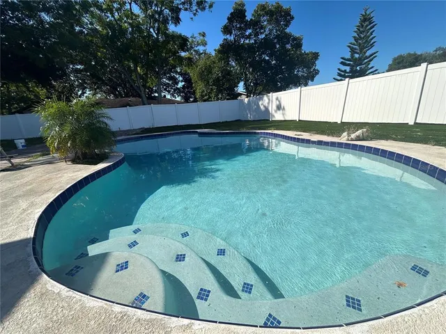 a view of a swimming pool with a yard