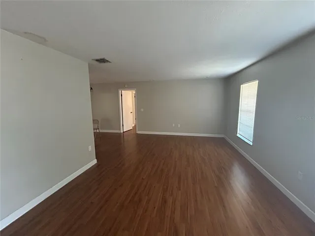 a view of a room with wooden floor and window