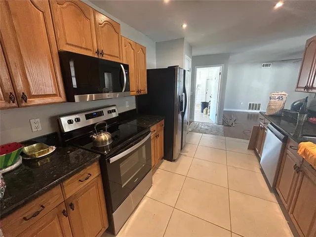 a kitchen with stainless steel appliances a stove a microwave a sink and a refrigerator