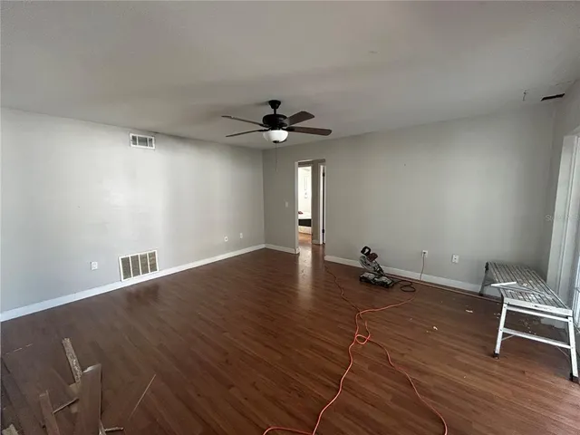 a view of room with a ceiling fan and wooden floor