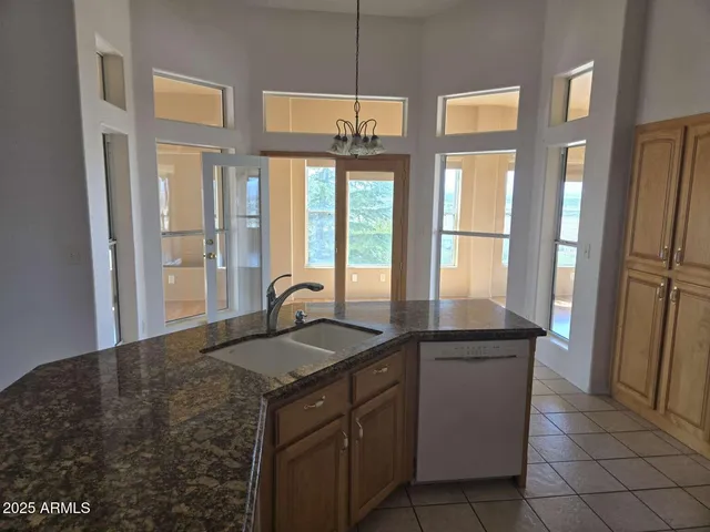 a kitchen with granite countertop a stove sink and cabinets