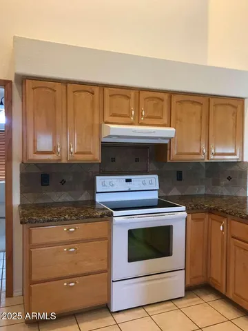 a kitchen with granite countertop white cabinets and white appliances