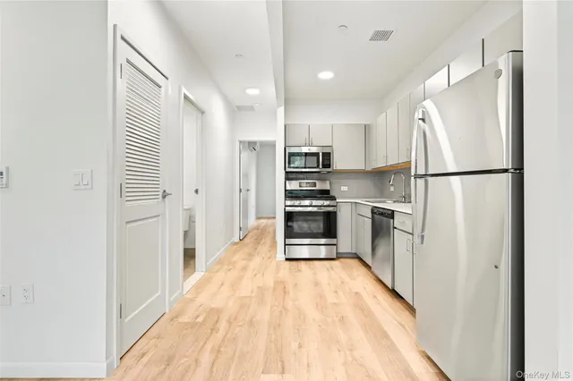 a kitchen with kitchen island wooden floor cabinets and appliances