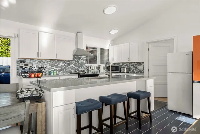 a kitchen with refrigerator and chairs