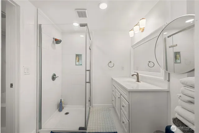 a bathroom with a double vanity sink mirror and shower
