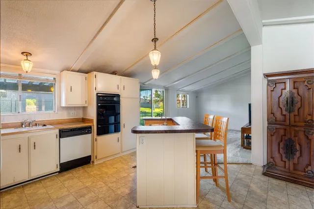 a kitchen with stainless steel appliances kitchen island granite countertop a sink refrigerator and cabinets