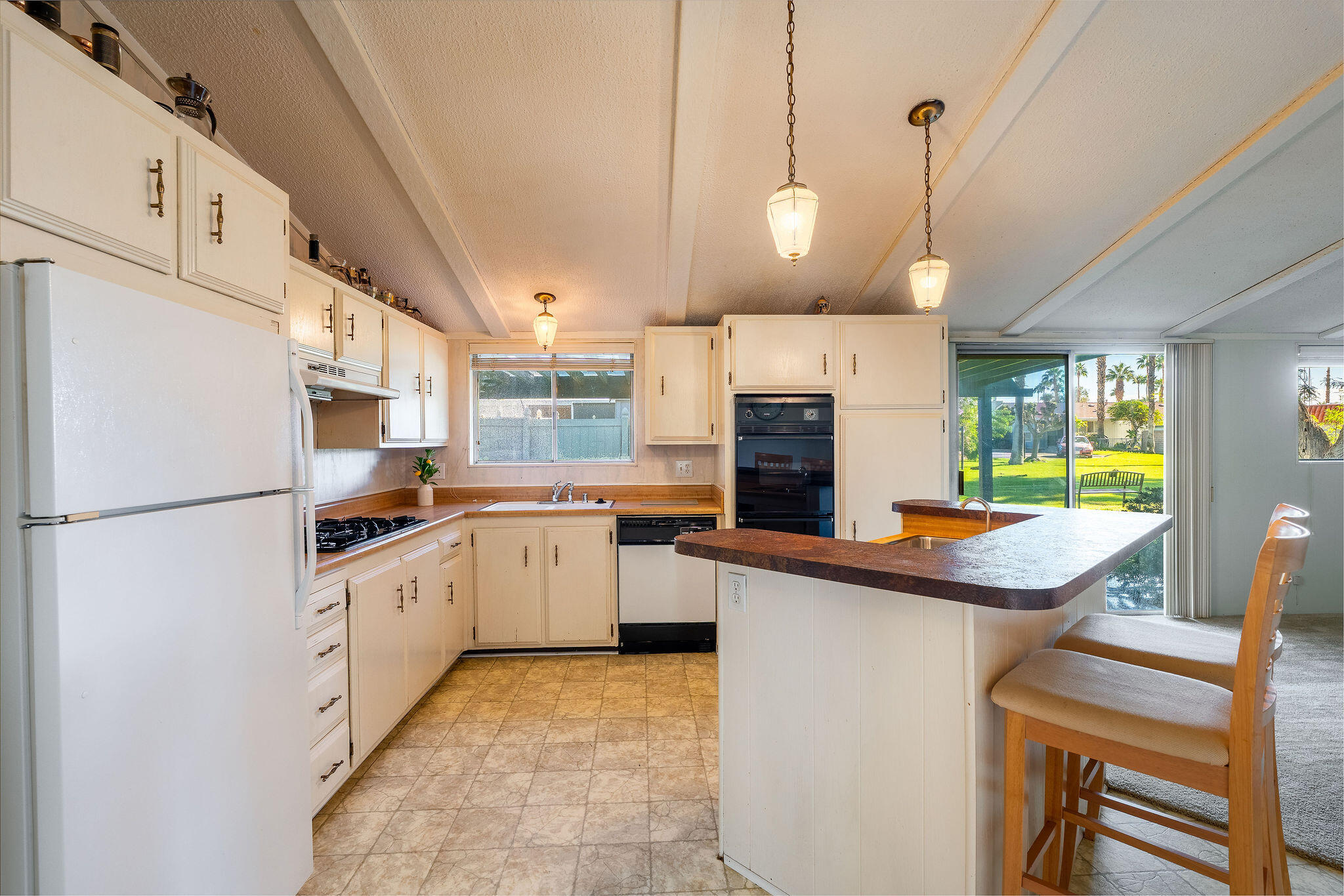 149 Capri Street Rancho Mirage, CA 92270 - Photo 15 of 50 a kitchen with stainless steel appliances granite countertop a sink a stove and a refrigerator