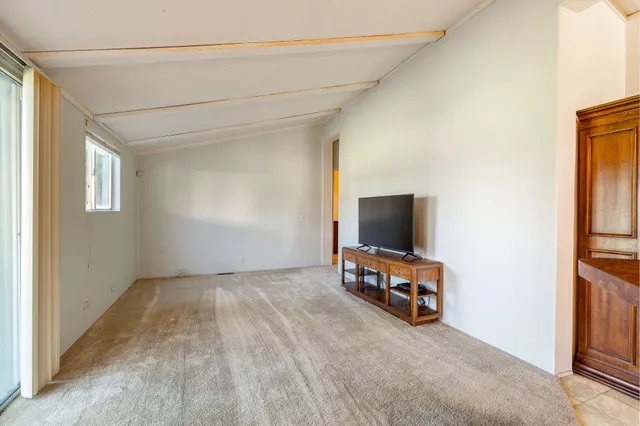 an empty room with furniture and a flat screen tv