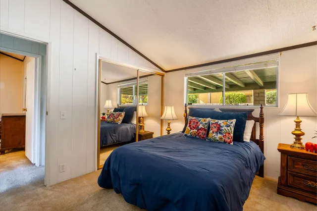 a bedroom with a bed and large windows