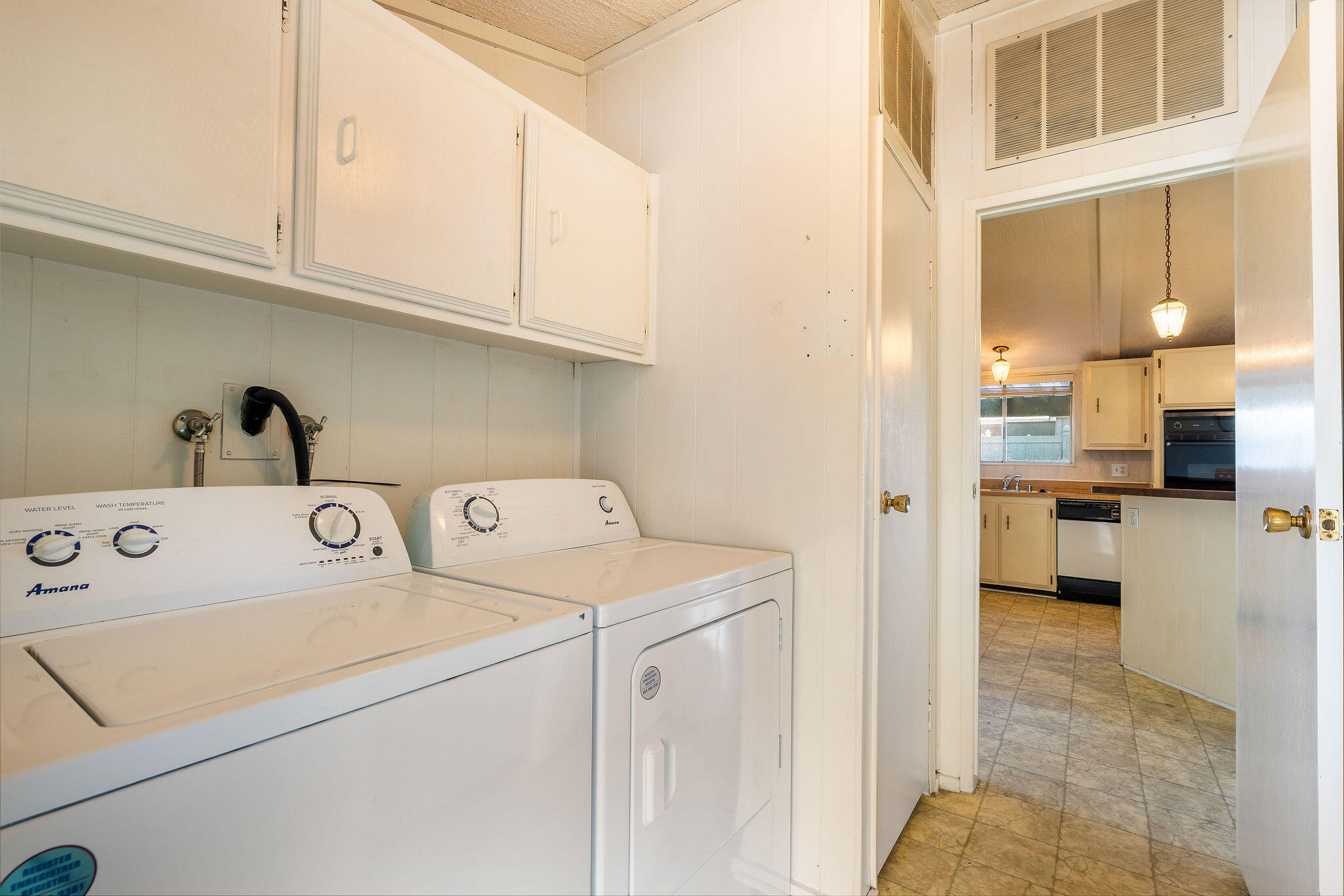 149 Capri Street Rancho Mirage, CA 92270 - Photo 28 of 50 a view of washer and dryer with kitchen in the background