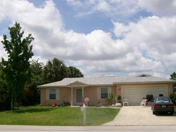 1298 Southwest Gideon Palm Bay, FL 32908 - Photo 1 of 1 a front view of a house with garden