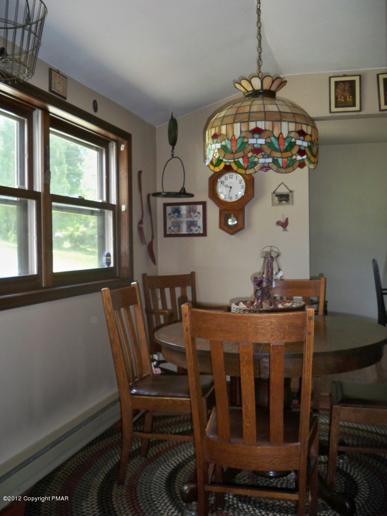5720 Neola Road Stroudsburg, PA 18360 - Photo 8 of 16 a view of a dining room with furniture a chandelier and a window