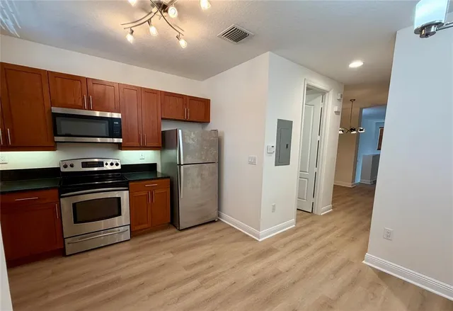 a kitchen with stainless steel appliances a stove a refrigerator and a sink