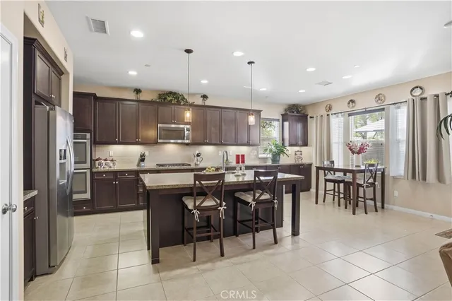 a kitchen with stainless steel appliances granite countertop sink window and dining table