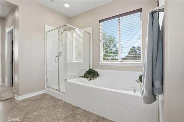 a bedroom with a large bed and a chandelier fan