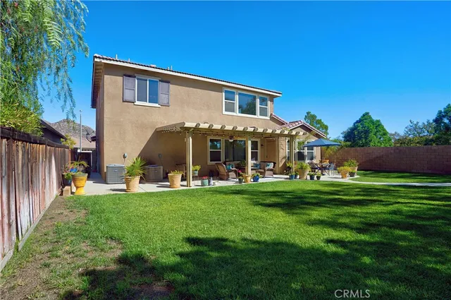 a view of a patio with couches table and chairs under an umbrella