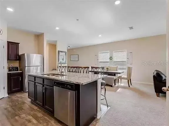 a kitchen that has a lot of cabinets a sink and a refrigerator in it
