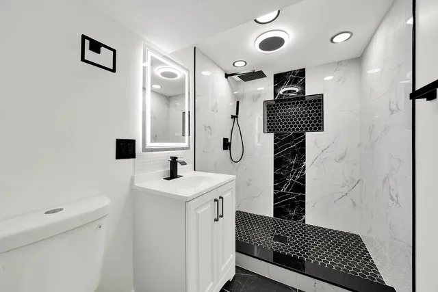 a bathroom with a sink a toilet and shower