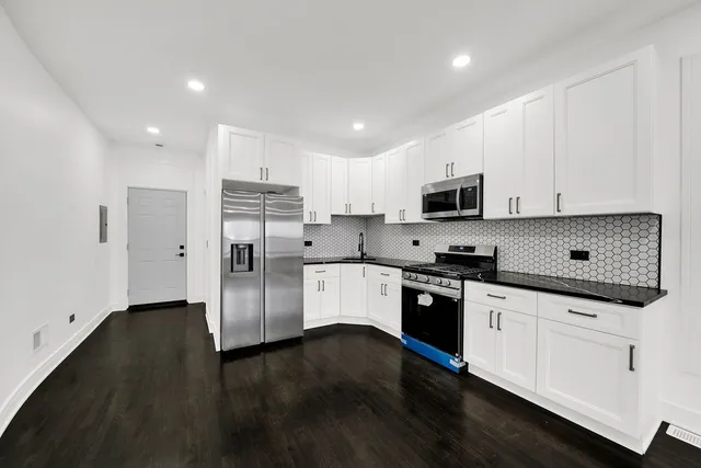 a kitchen with stainless steel appliances granite countertop a refrigerator and a stove top oven