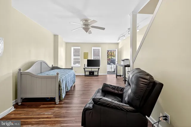 a living room with furniture and a wooden floor