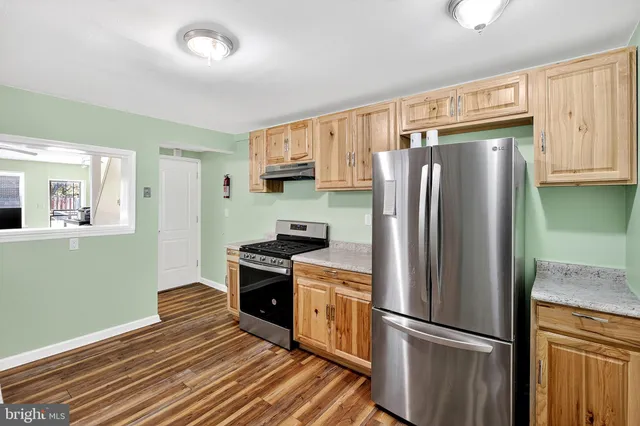 a kitchen with granite countertop stainless steel appliances a refrigerator cabinets and a sink