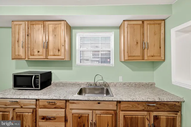 a kitchen with stainless steel appliances granite countertop a sink and a microwave