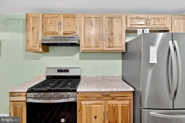 a kitchen with stainless steel appliances granite countertop a stove a refrigerator and a cabinets