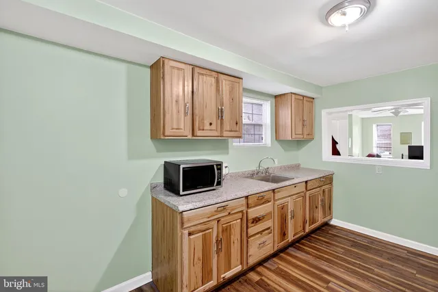 a kitchen with stainless steel appliances granite countertop a sink and a stove with wooden floor