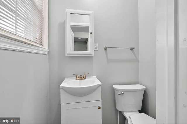 a bathroom with a toilet sink and mirror