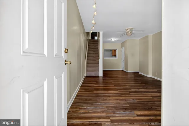 a view of a hallway with wooden floor and staircase