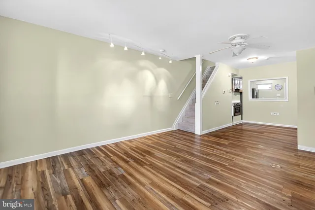 a view of a room with wooden floor and ceiling fan