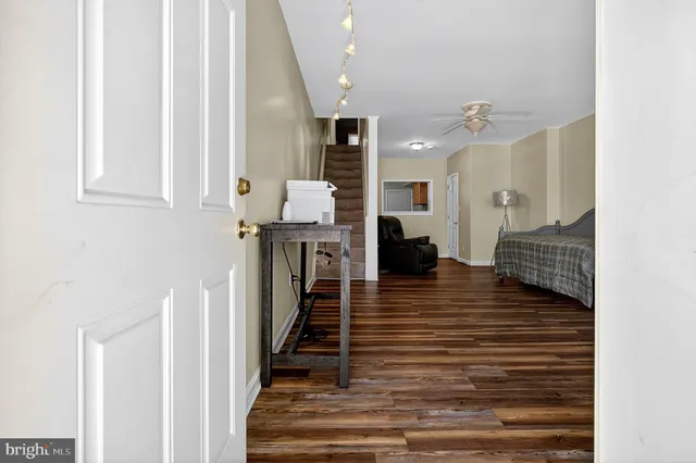 a view of a hallway with wooden floor and staircase