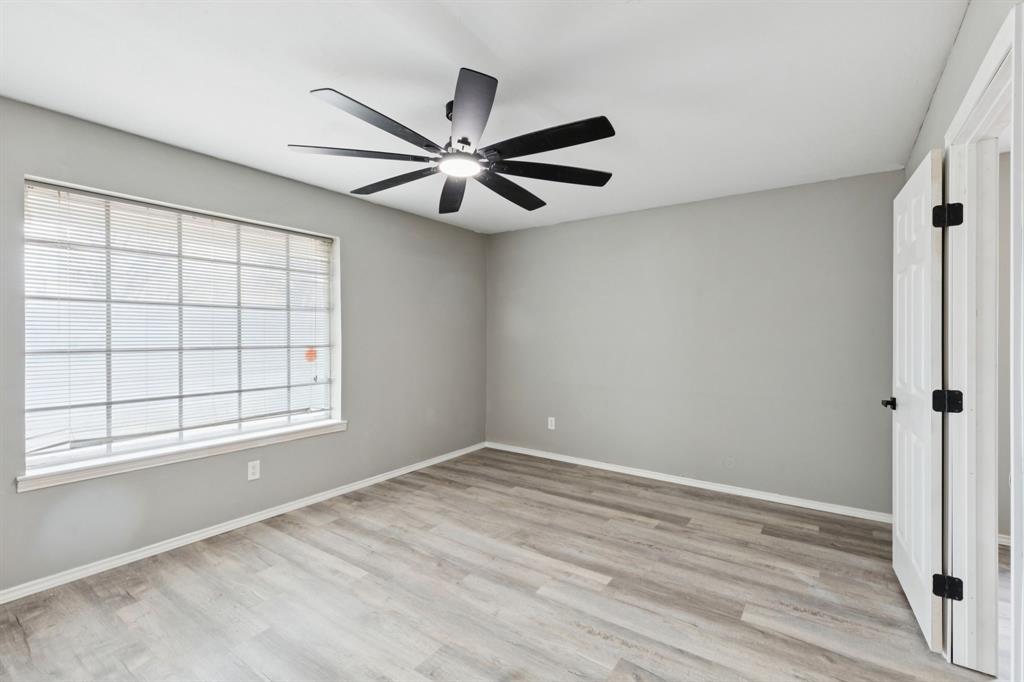 9643 Altacrest Drive Dallas, TX 75227 - Photo 12 of 30 a view of an empty room with a window and wooden floor