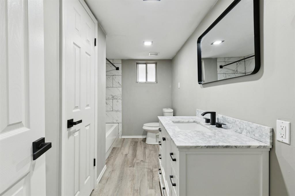 9643 Altacrest Drive Dallas, TX 75227 - Photo 16 of 30 a bathroom with a sink a mirror a vanity and a shower