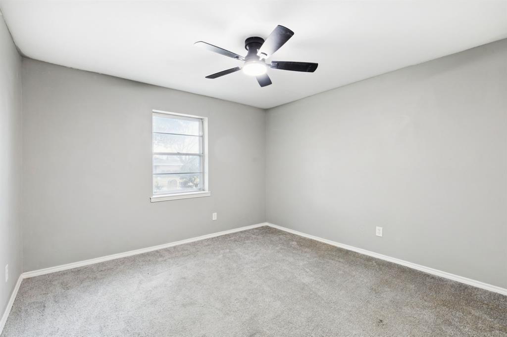 9643 Altacrest Drive Dallas, TX 75227 - Photo 18 of 30 an empty room with ceiling fan and window