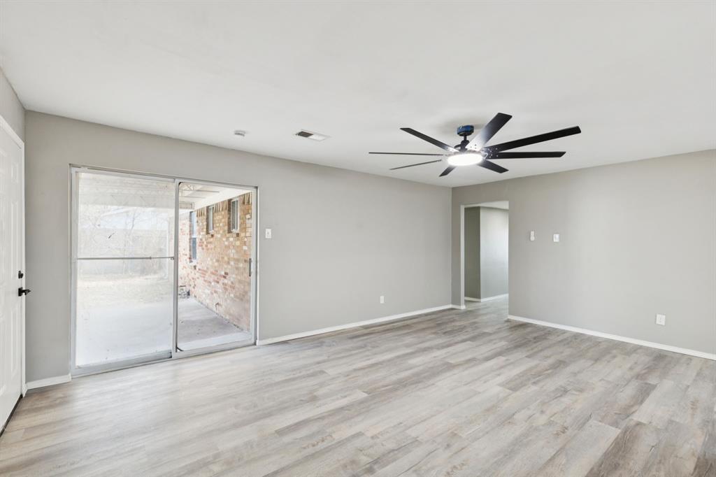9643 Altacrest Drive Dallas, TX 75227 - Photo 3 of 30 a view of a livingroom with a ceiling fan and wooden floor