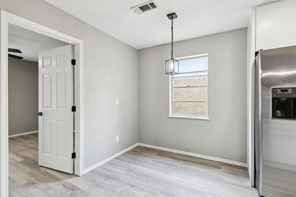 9643 Altacrest Drive Dallas, TX 75227 - Photo 7 of 30 a view of an empty room with window and wooden floor