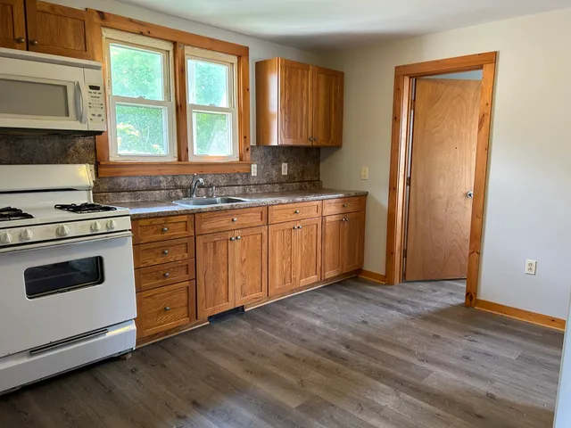 a kitchen with granite countertop wooden floors and sink