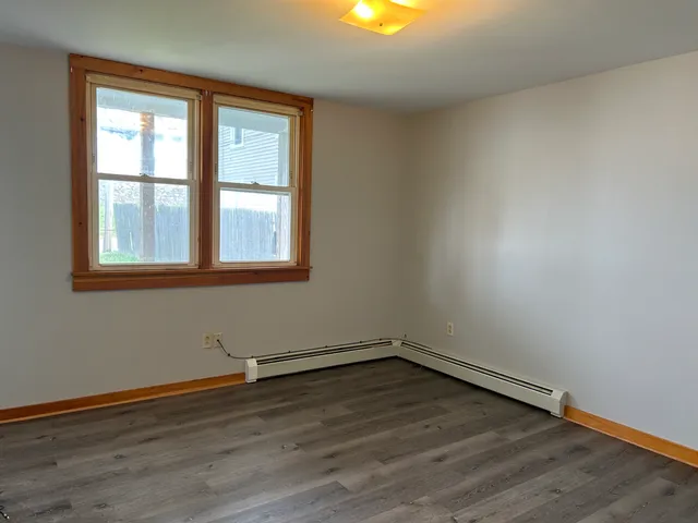 a view of a room with wooden floors and window