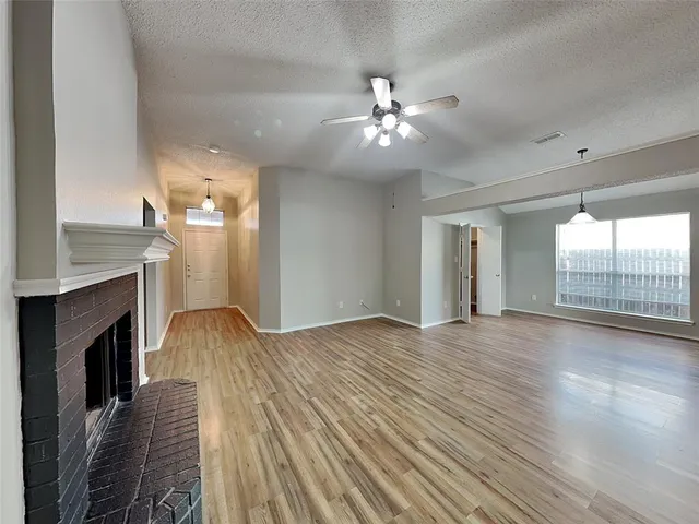 a view of livingroom with fireplace wooden floor and chandelier