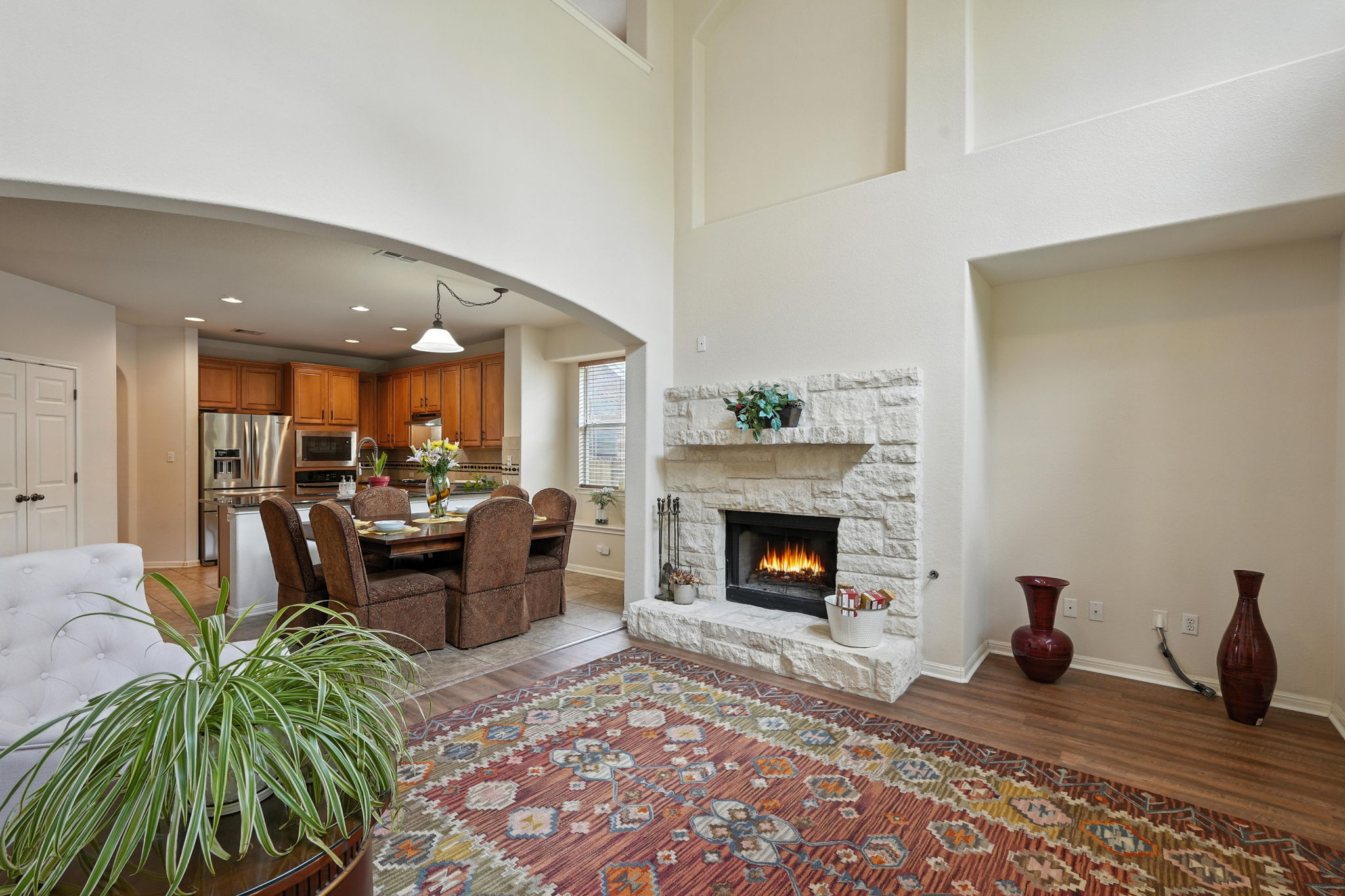 1802 Misty Ridge Leander, TX 78641 - Photo 20 of 39 Living room featuring light wood finished floors, arched walkways, a stone fireplace, a high ceiling, and recessed lighting