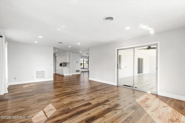 a view of empty room with wooden floor