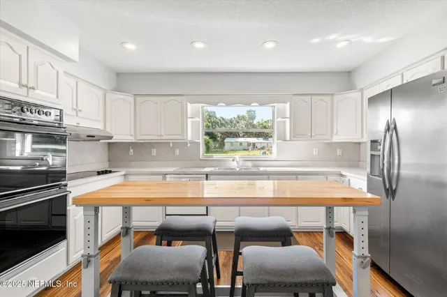 a kitchen with a table chairs and a refrigerator