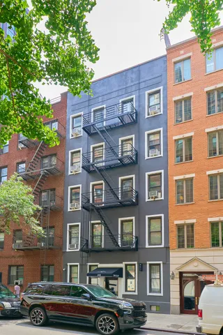 a front view of a building with lot of cars parked